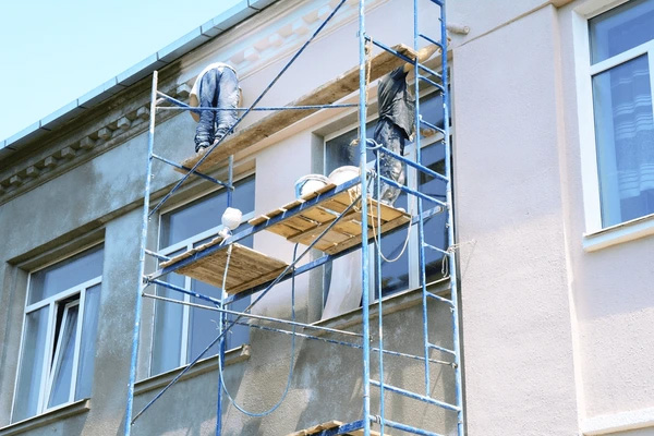 Façadier appliquant un enduit de finition sur un mur extérieur
